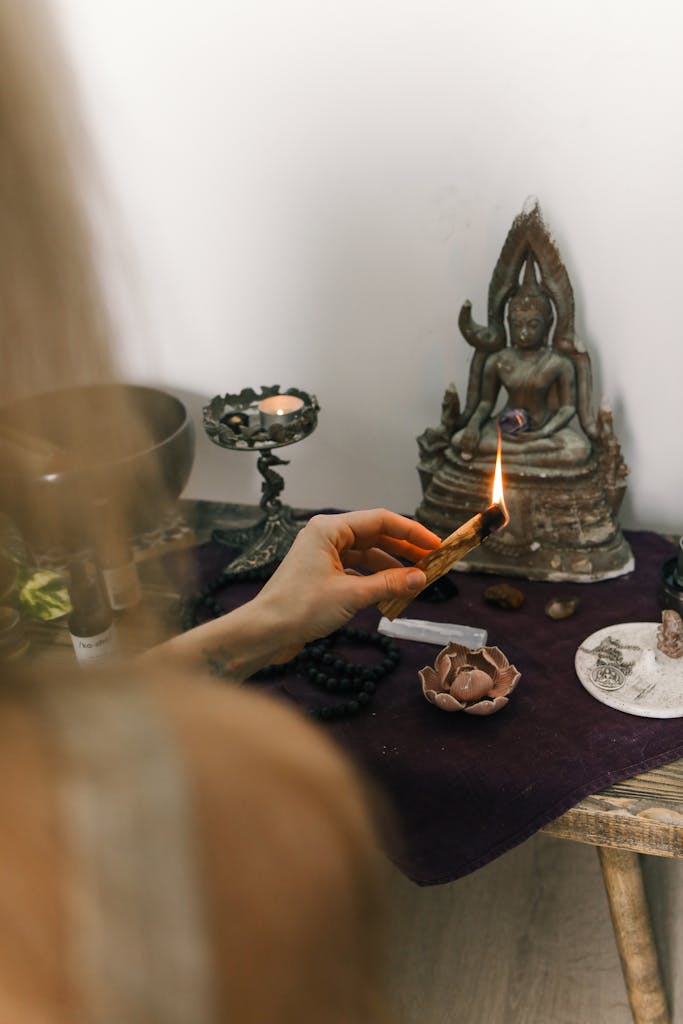 A serene spiritual setup with sage burning beside a Buddha statue, promoting calm and meditation.